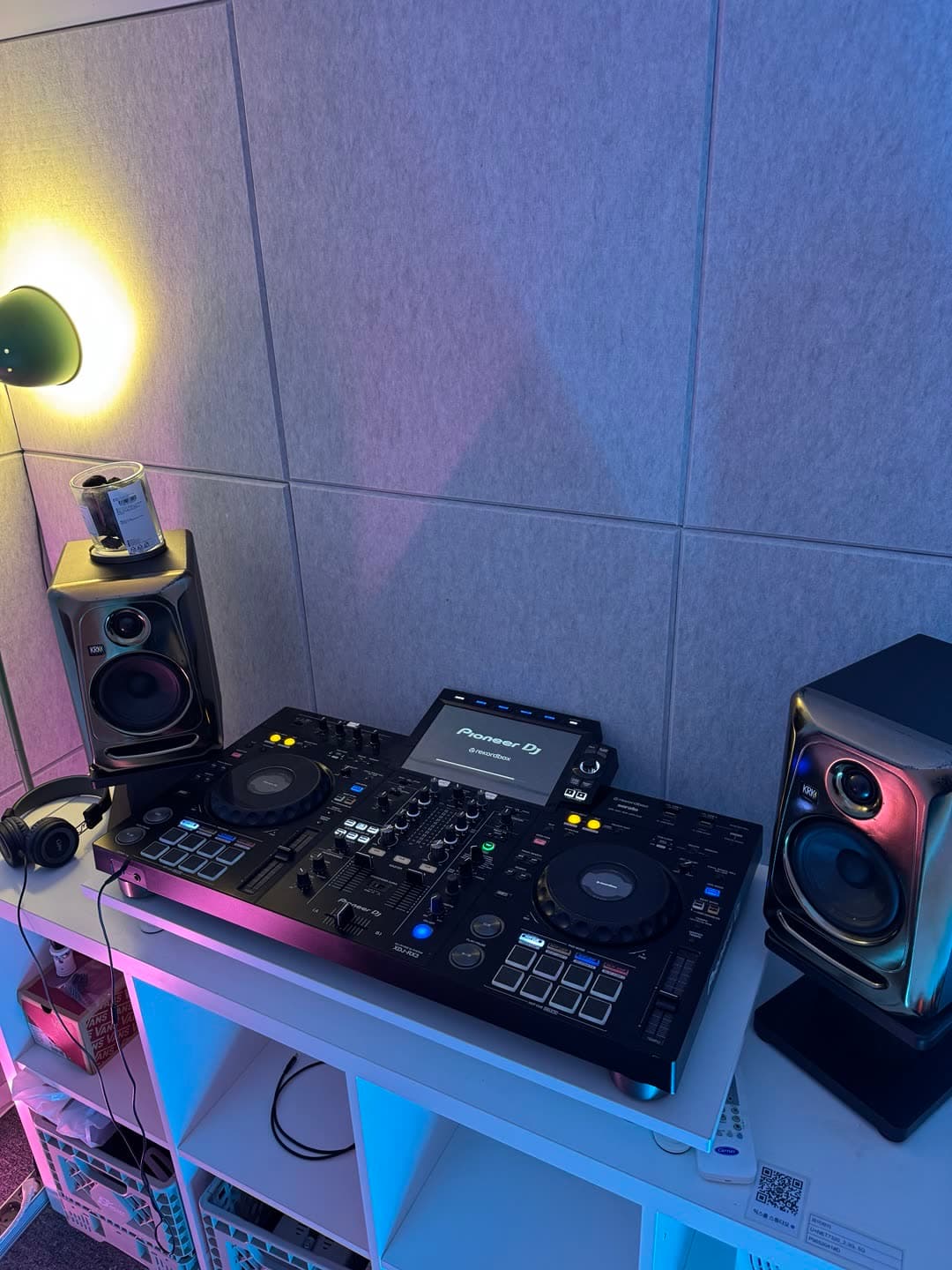 은은한 조명 아래 DJ 컨트롤러와 모니터 스피커가 놓인 믹스룸 연습실 부스.